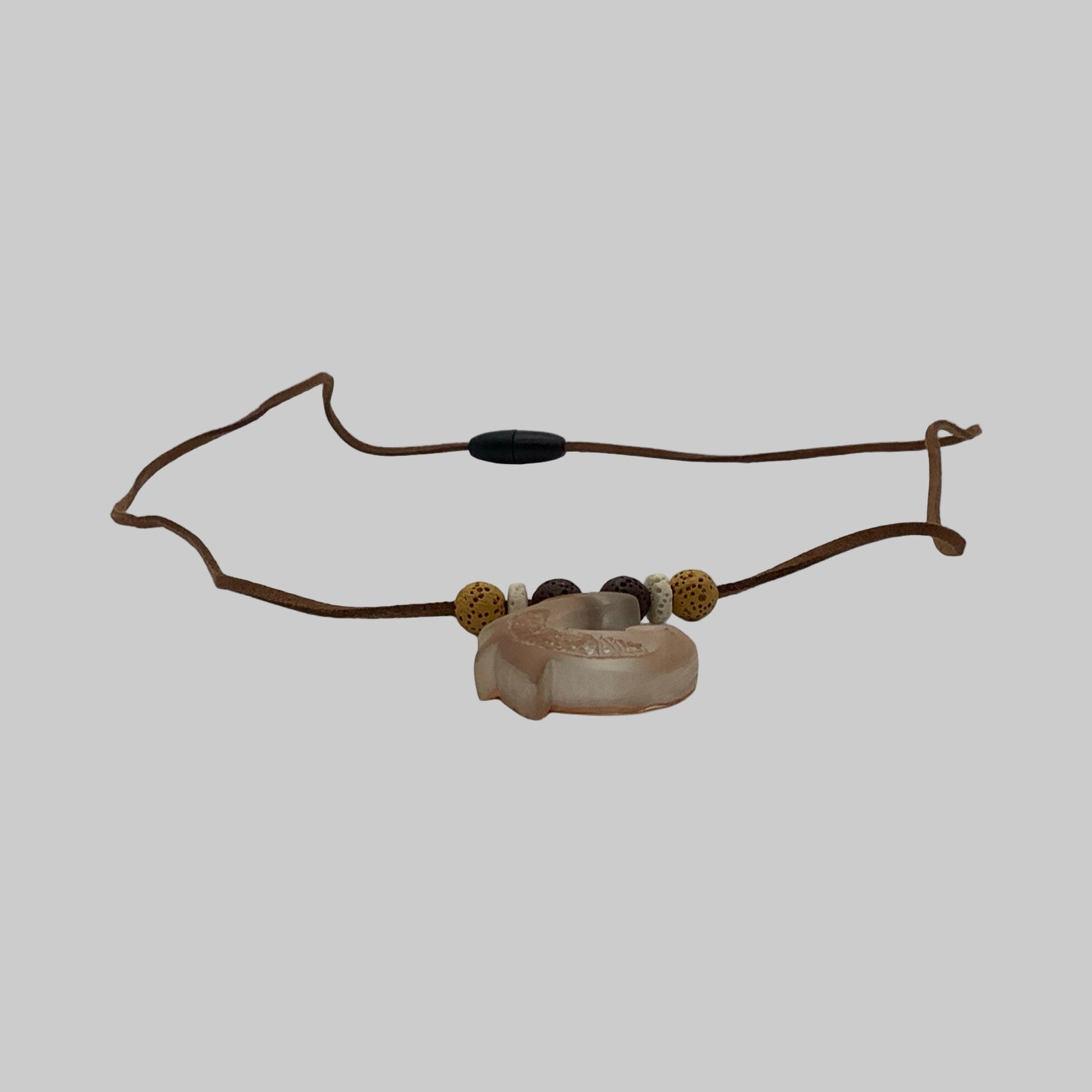 Necklace with stone bead and brown cord on a white background