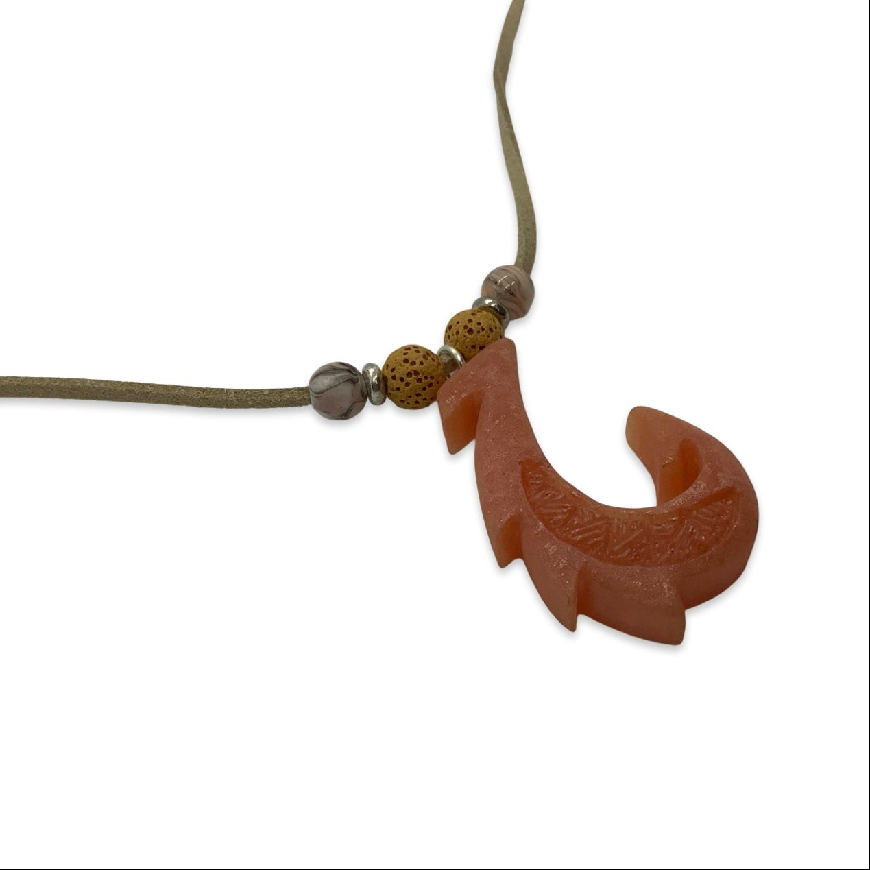 Dusty orange  fish-shaped pendant on a cord against a white background