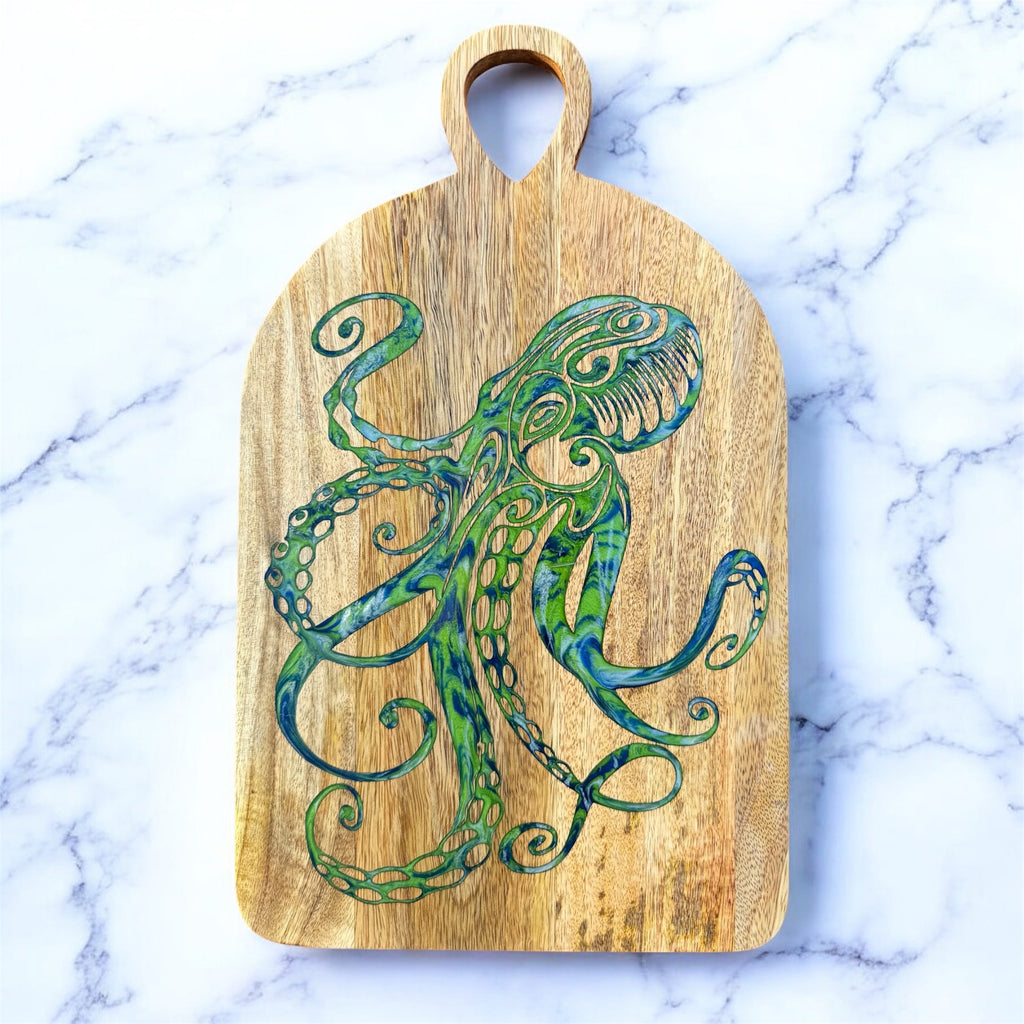 Wooden cutting board with a green octopus design on a marble background