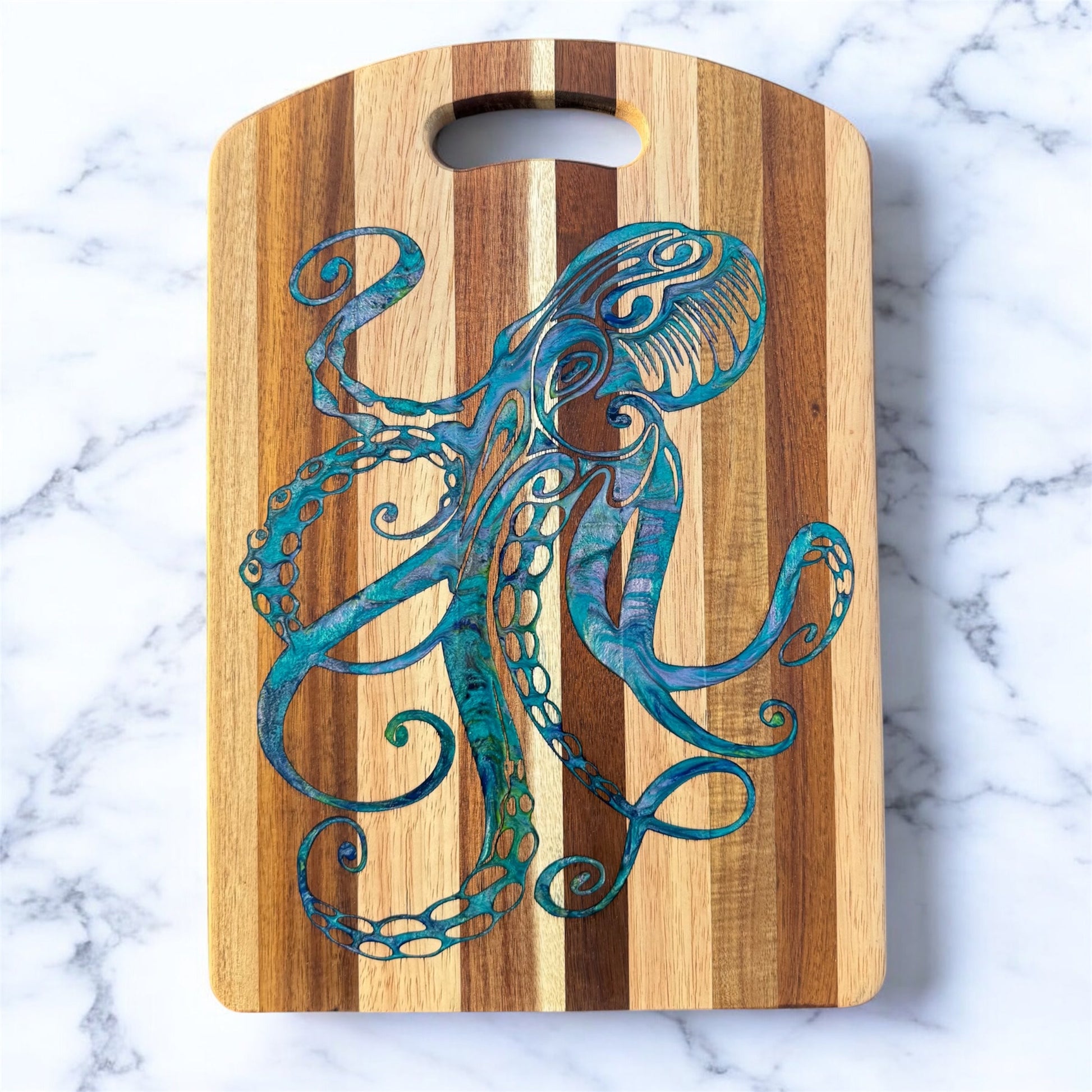 Wooden cutting board with a blue octopus design on a marble surface