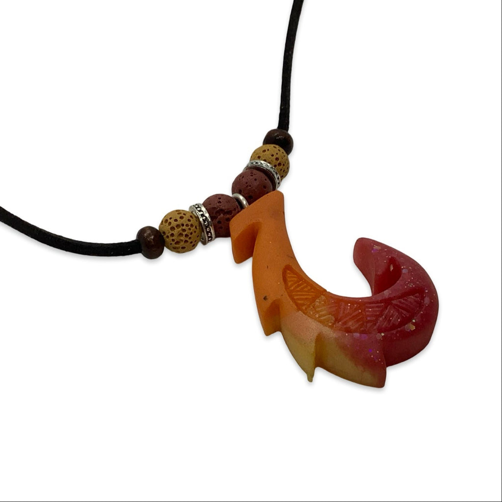 Necklace with a fish hook pendant and beads on a white background