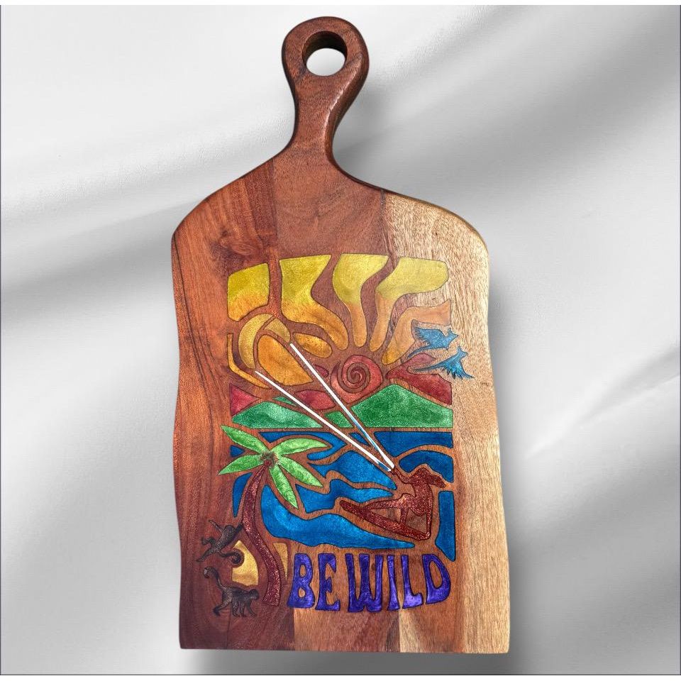 Wooden cutting board with colorful design and 'BE WILD' text on a gray background