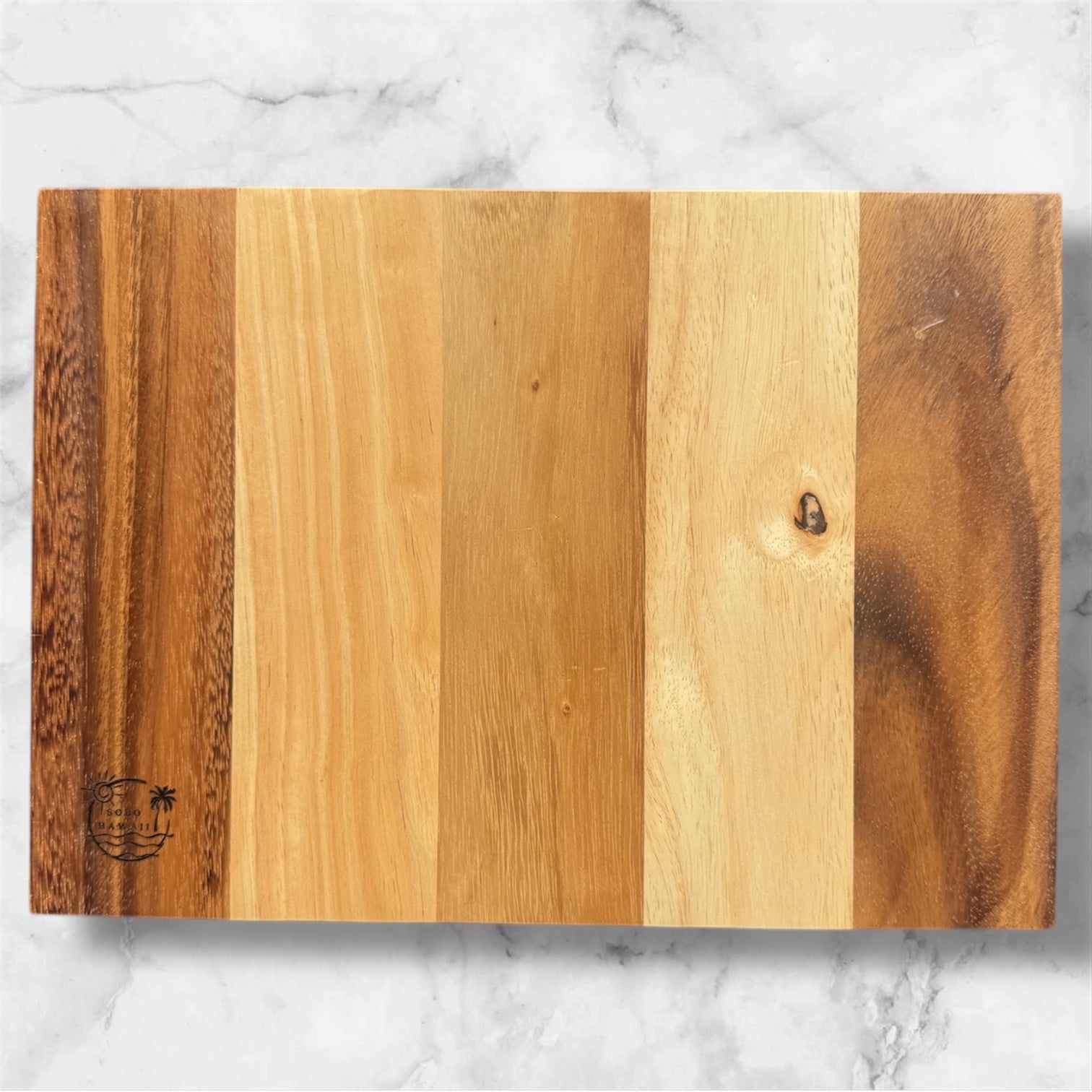 Wooden cutting board with a striped pattern on a marble surface