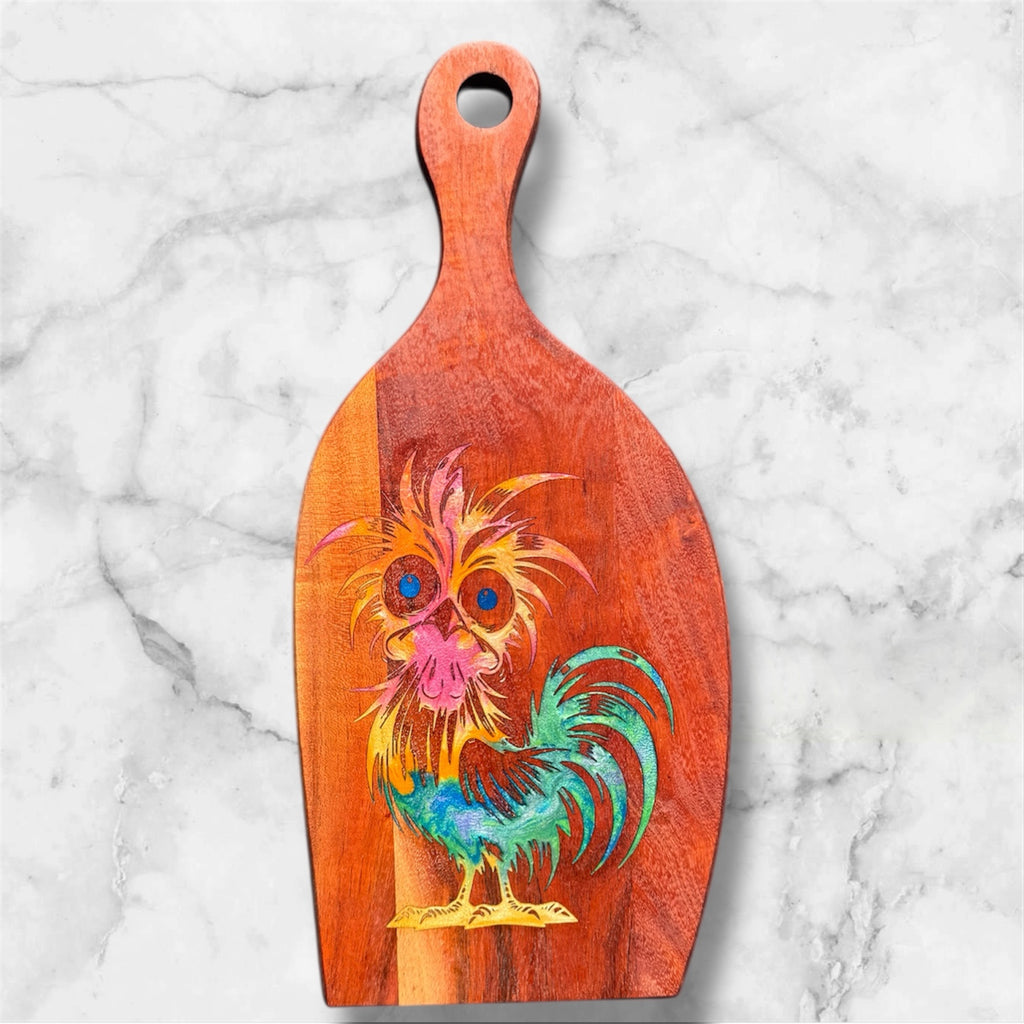 Wooden paddle with a colorful rooster design on a marble background