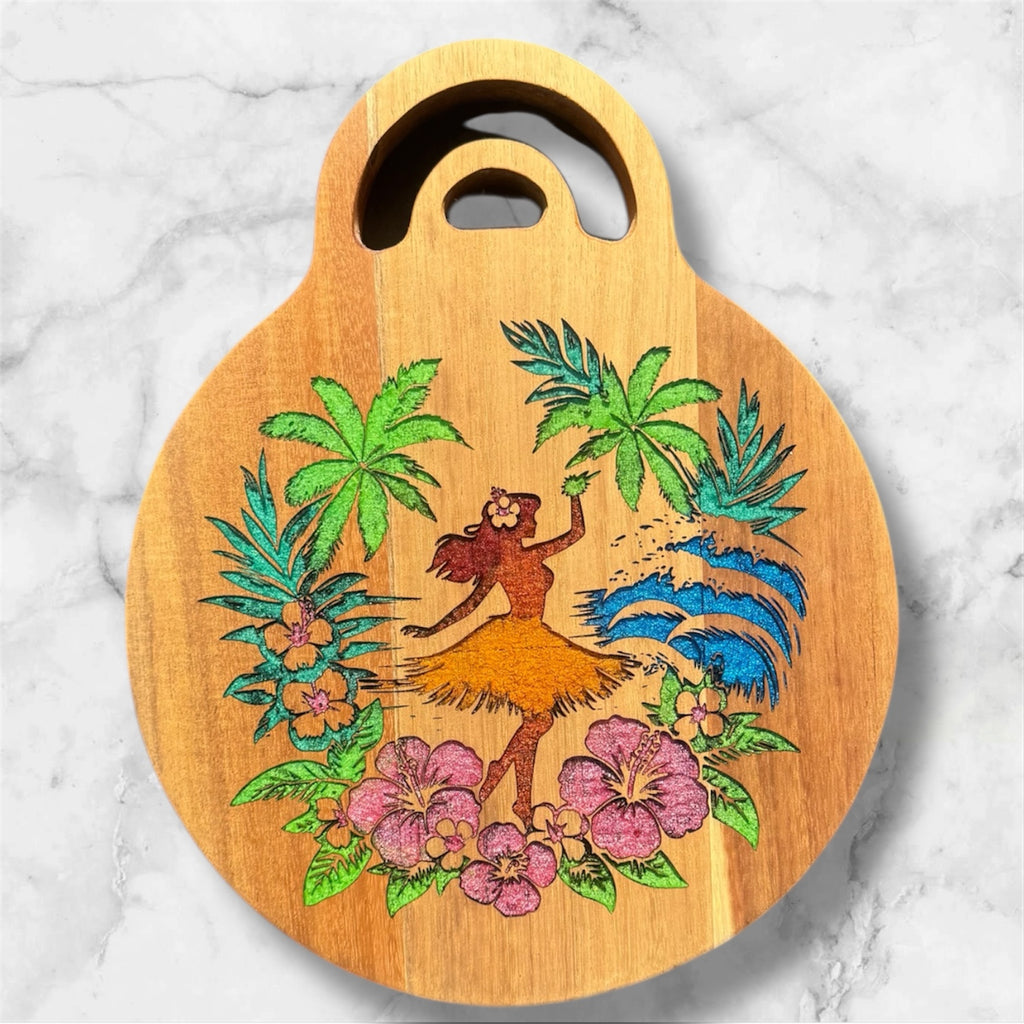 Wooden cutting board with a hula dancer and tropical designs on a marble background