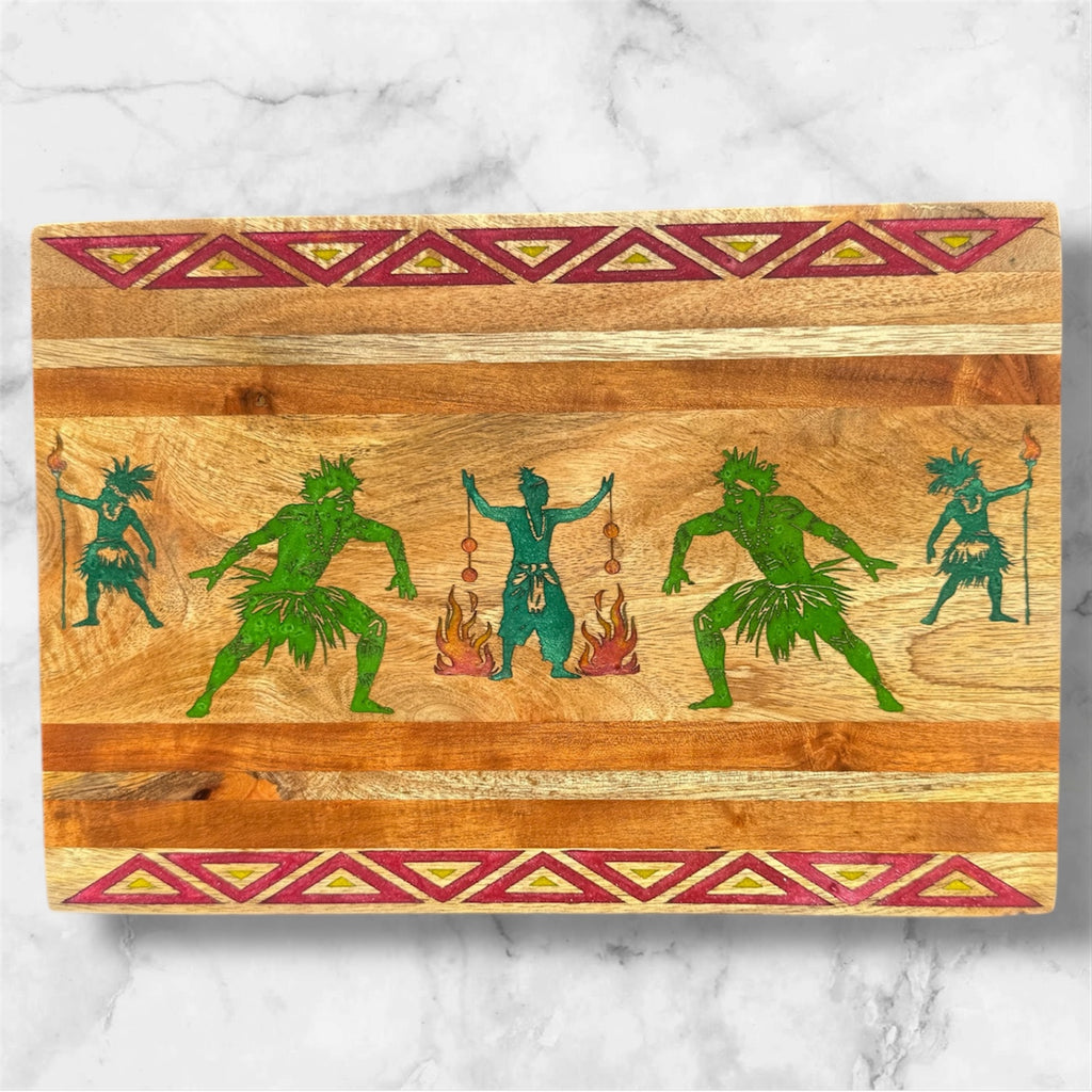 Wooden cutting board with green and blue tribal figures and red geometric patterns on a marble background