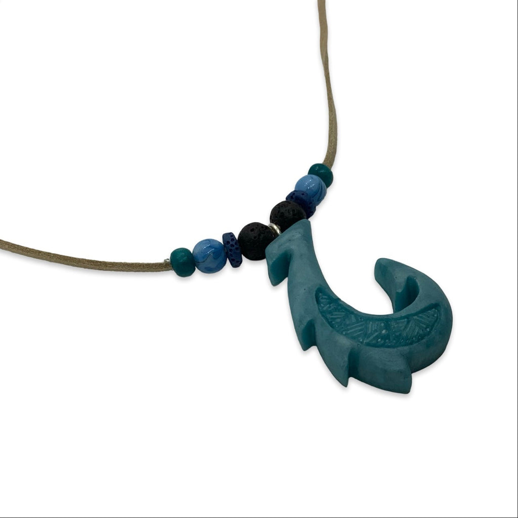 Necklace with a blue leaf-shaped pendant and beads on a white background